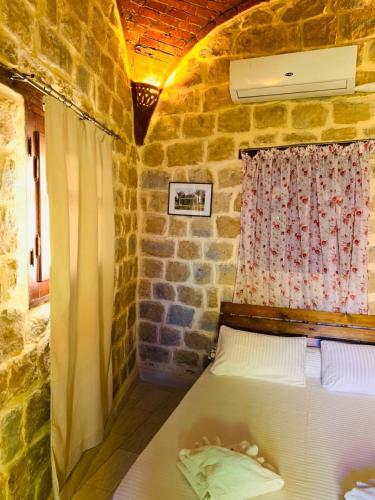 a bedroom with a bed in a stone room at palm shadow resort in Tunis