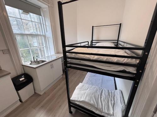 a room with two bunk beds and a sink at Haymarket Hostel in Edinburgh