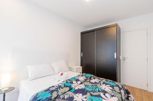 a bedroom with a bed and a closet at Viva nas Alturas 2 Quartos com Vaga - UNI2707 in Curitiba