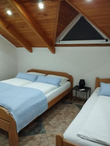 two beds in a room with a window at City villa Bihac in Bihać