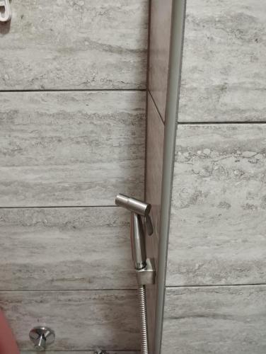 a bathroom door with a shower handle on a wooden wall at City villa Bihac in Bihać