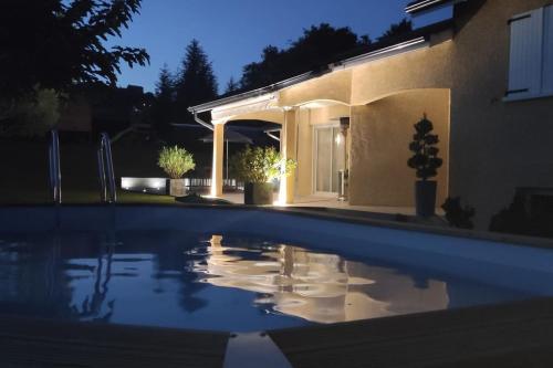 une piscine devant une maison la nuit dans l'établissement Belle villa familiale à la campagne et sa piscine, à Chevrières