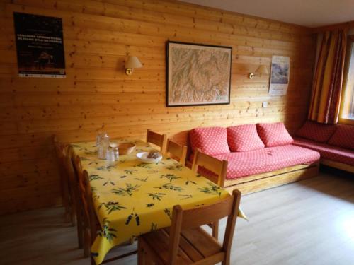 une salle à manger avec une table et un canapé dans l'établissement Résidence Les Glaciers 3 - 3 Pièces pour 7 Personnes 191, à Aime La Plagne