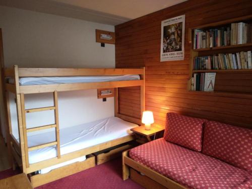 - une chambre avec des lits superposés, un canapé et une étagère dans l'établissement Résidence Les Glaciers 3 - 3 Pièces pour 7 Personnes 191, à Aime La Plagne