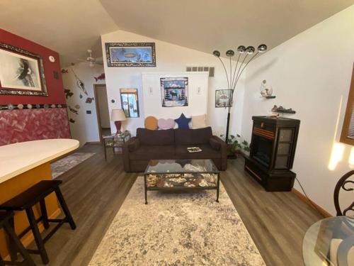 a living room with a couch and a fireplace at Alaska's Point of View Full Suite in Seward