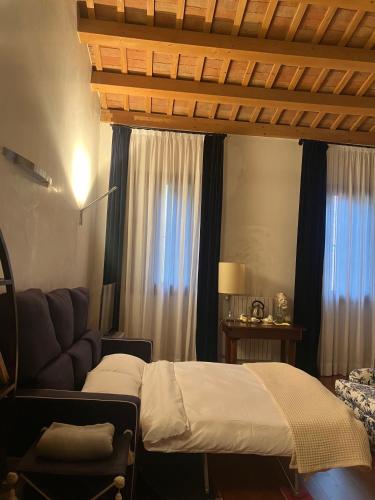 a bedroom with a bed and a couch and windows at Ciao Amore in Padova