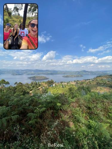 a group of people sitting on a hill overlooking a lake at Bonnie's Homestay in Gasanze