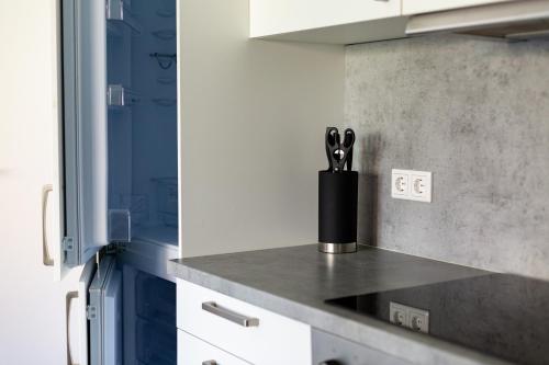 a kitchen counter with a container of kitchen utensils at BEST STAY CityAppartment Hünfeld- SmartTV FreeWlan Balkon, in wenigen Minuten am Bahnhof, Innenstadt und doch ruhig gelegen - ideal für Paare oder Geschäftsreisen in Hünfeld