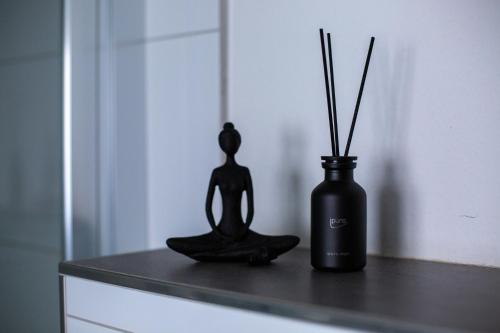 a black statue sitting on a counter next to a vase at BEST STAY CityAppartment Hünfeld- SmartTV FreeWlan Balkon, in wenigen Minuten am Bahnhof, Innenstadt und doch ruhig gelegen - ideal für Paare oder Geschäftsreisen in Hünfeld