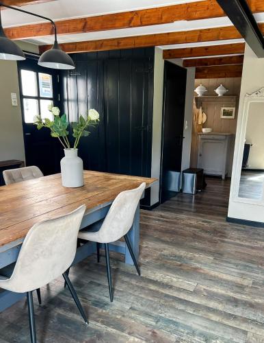 a dining room with a wooden table and chairs at De Koolschuur in Heerhugowaard