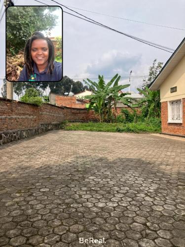 a picture of a woman smiling on a brick road at Bonnie's Homestay in Gasanze