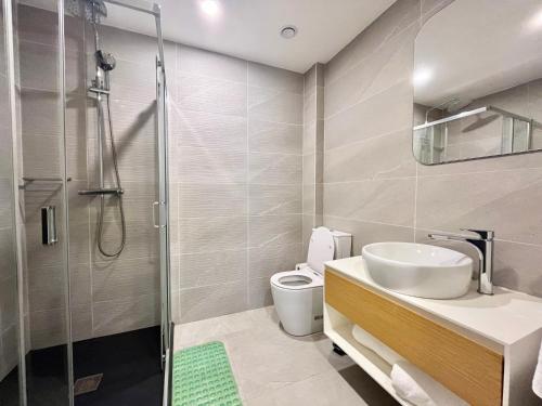 a bathroom with a shower and a sink and a toilet at Elegant 2-Bed Rooms at Kololi Sands in Kololi