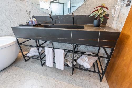 a bathroom with a sink and towels on a shelf at Aruanã Eco Praia Hotel in Aracaju