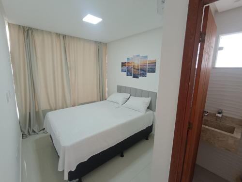 a small bedroom with a bed and a shower at Mansão Climatizada com piscina e churrasqueira in Camaçari