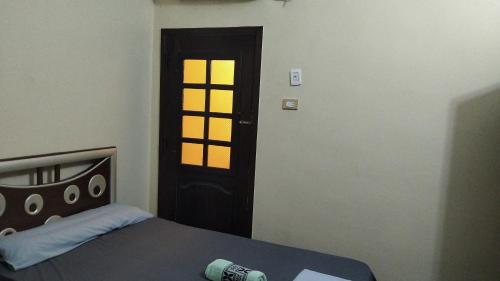 a bedroom with a bed and a door with a window at Aswan Nile view house in Aswan