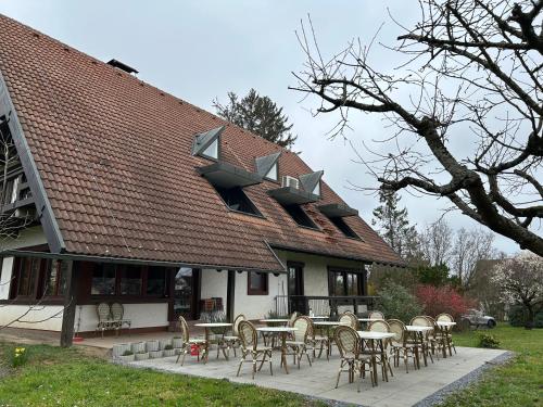 a group of tables and chairs in front of a house at Gästehaus Obsthof Gottenheim in Gottenheim