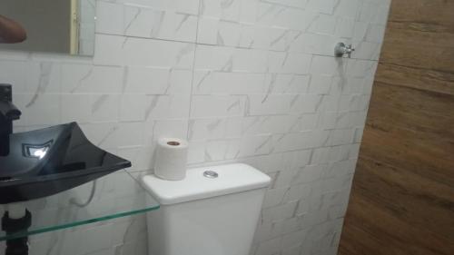 een witte badkamer met een rol toiletpapier op de tank bij Hotel Maracanã in Sao Paulo