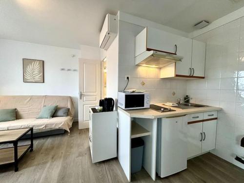 une cuisine et un salon avec un canapé dans l'établissement L'Océane, Spacieux, Proche plage, à La Palud