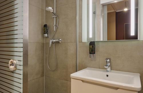 a bathroom with a shower and a sink at Leonardo Boutique Hotel Munich in Munich