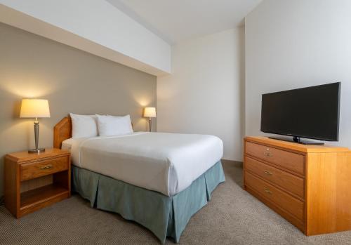 a hotel room with a bed and a flat screen tv at DEV Hotel and Conference Centre in Cornwall