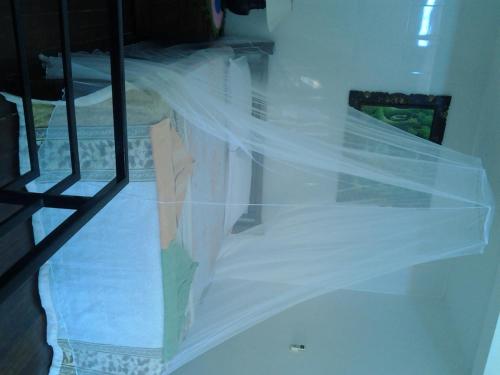 a woman standing on a bed under a veil at Tirta Yoga Inn in Padangbai