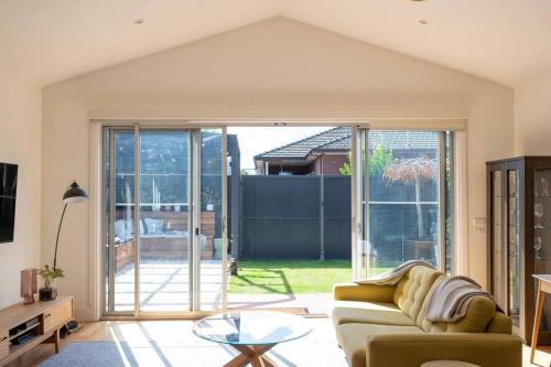 a living room with a couch and a glass table at Spacious light-filled 3BD sanctuary in Northcote in Melbourne
