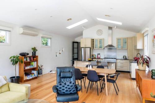 a kitchen and living room with a table and chairs at Spacious light-filled 3BD sanctuary in Northcote in Melbourne