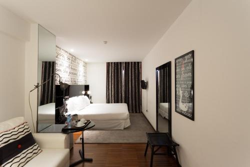 a hotel room with two beds and a couch at Porto Trindade Hotel in Porto