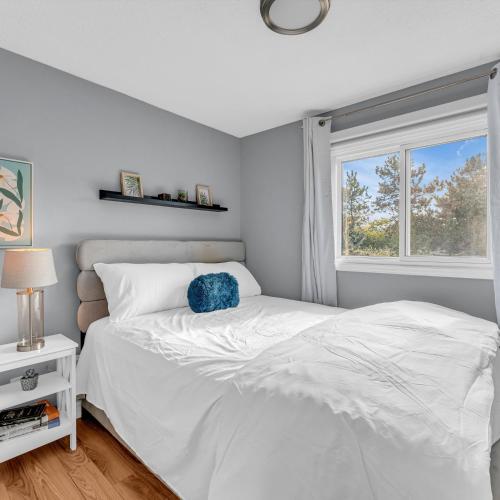 a white bed in a bedroom with a window at Retro Arcade & Gaming Home by Pako Stays in Brampton
