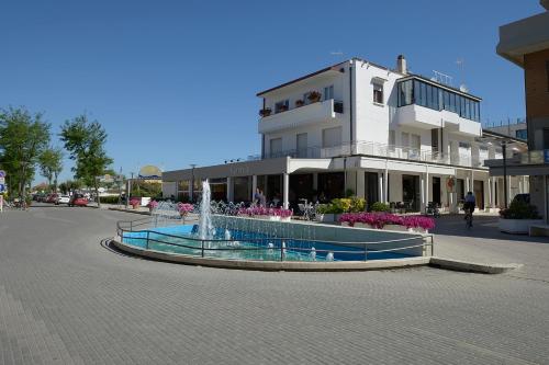 un edificio con una fuente en medio de una calle en Hotel Villa Boschetti, en San Mauro a Mare