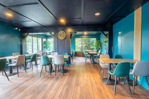 a restaurant with blue walls and tables and chairs at Kyriad Direct Laon in Laon