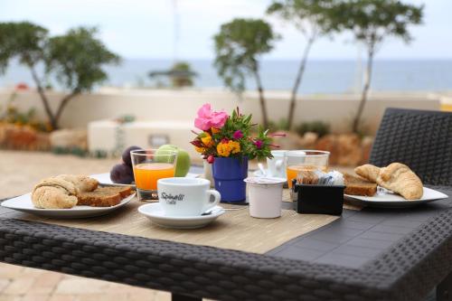 un tavolo con colazione a base di pane tostato, caffè e succo d'arancia di B&B Lu Cantoru a Marina di Pescoluse