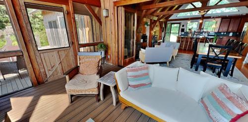 a porch with a couch and chairs on a deck at The Lakehouse of Braeloch in Colchester