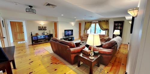 a living room with leather couches and a television at The Lakehouse of Braeloch in Colchester