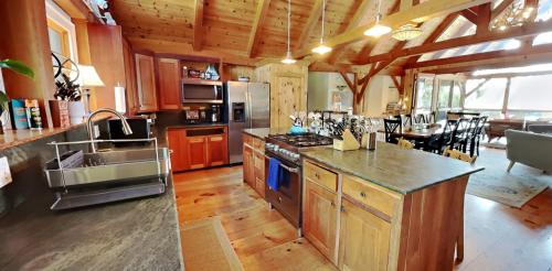 a large kitchen with wooden cabinets and a counter top at The Lakehouse of Braeloch in Colchester