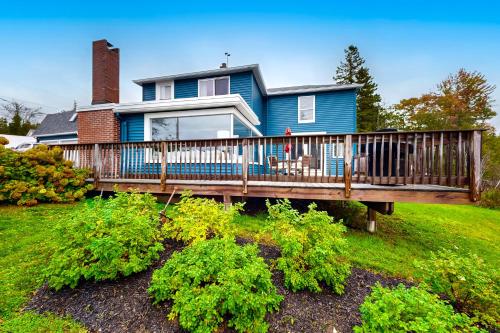 a blue house with a wooden deck in the yard at Pound House in Hancock