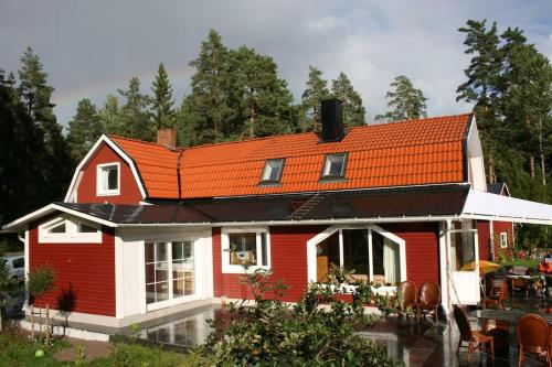 a red and white house with an orange roof at Apartment in recreational area close to the city in Örebro
