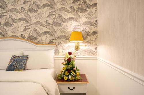 a small christmas tree on a night stand next to a bed at Hotel Villa Morra Suites in Asuncion