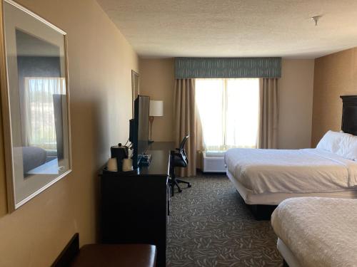 a hotel room with two beds and a television at Hampton Inn & Suites Carlsbad in Carlsbad