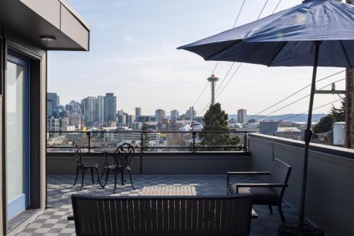 a balcony with a table and chairs and an umbrella at Modern Townhome with Space Needle View in Seattle