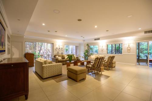 a large living room with chairs and a table at Hotel Villa Morra Suites in Asuncion