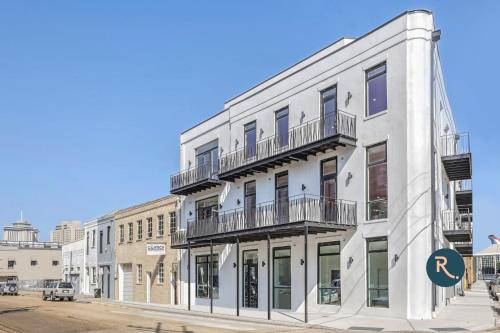 a white building with balconies on a city street at Roami at The Churchill in New Orleans