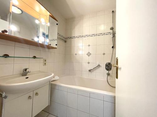 a bathroom with a bath tub and a sink at Apartmenthaus Frauenpreiss FeWo 303 in Cuxhaven