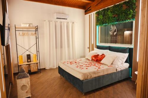 パレルモにあるCala Sikula Suite &SPAの赤い花が飾られたベッドのある寝室