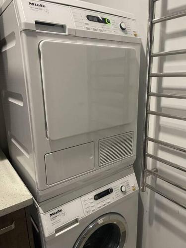 a washing machine and a dryer in a room at Winter Fun - Spa, Pinball, Billiard and more in Kumeu
