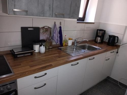 a kitchen with a sink and a wooden counter top at Ruhig gelegene Wohnung Am Schlosspark in Biebrich