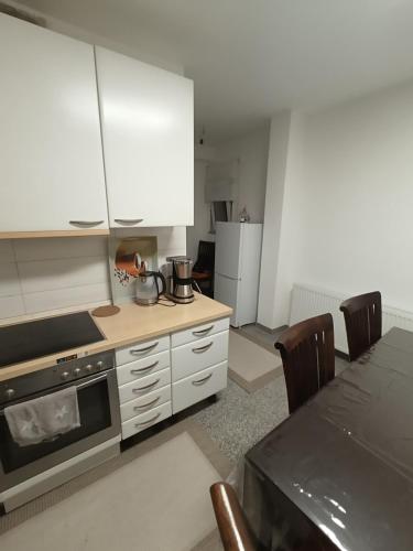 a kitchen with white cabinets and a table with chairs at Ruhig gelegene Wohnung Am Schlosspark in Biebrich