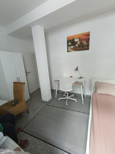 a room with a desk and a bed and a table at Ruhig gelegene Wohnung Am Schlosspark in Biebrich