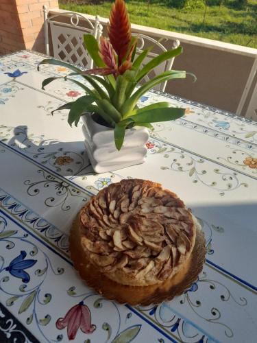 a pastry on a table next to a vase with a flower at Terra Vitale in Cava deʼ Tirreni
