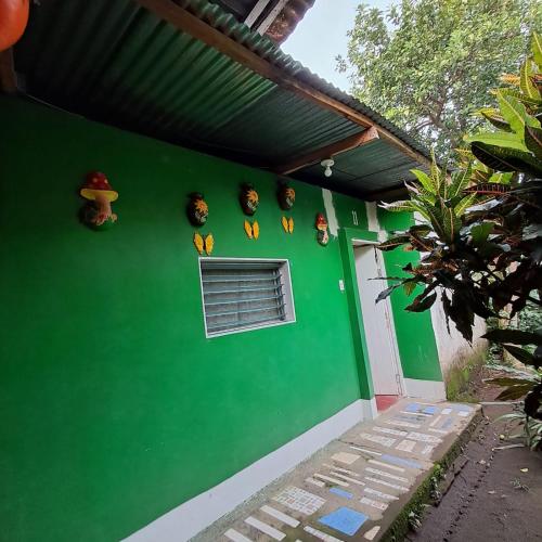 a green wall with a bunch of clocks on it at Hospedaje y Restaurante la cocina de Mami in Moyogalpa